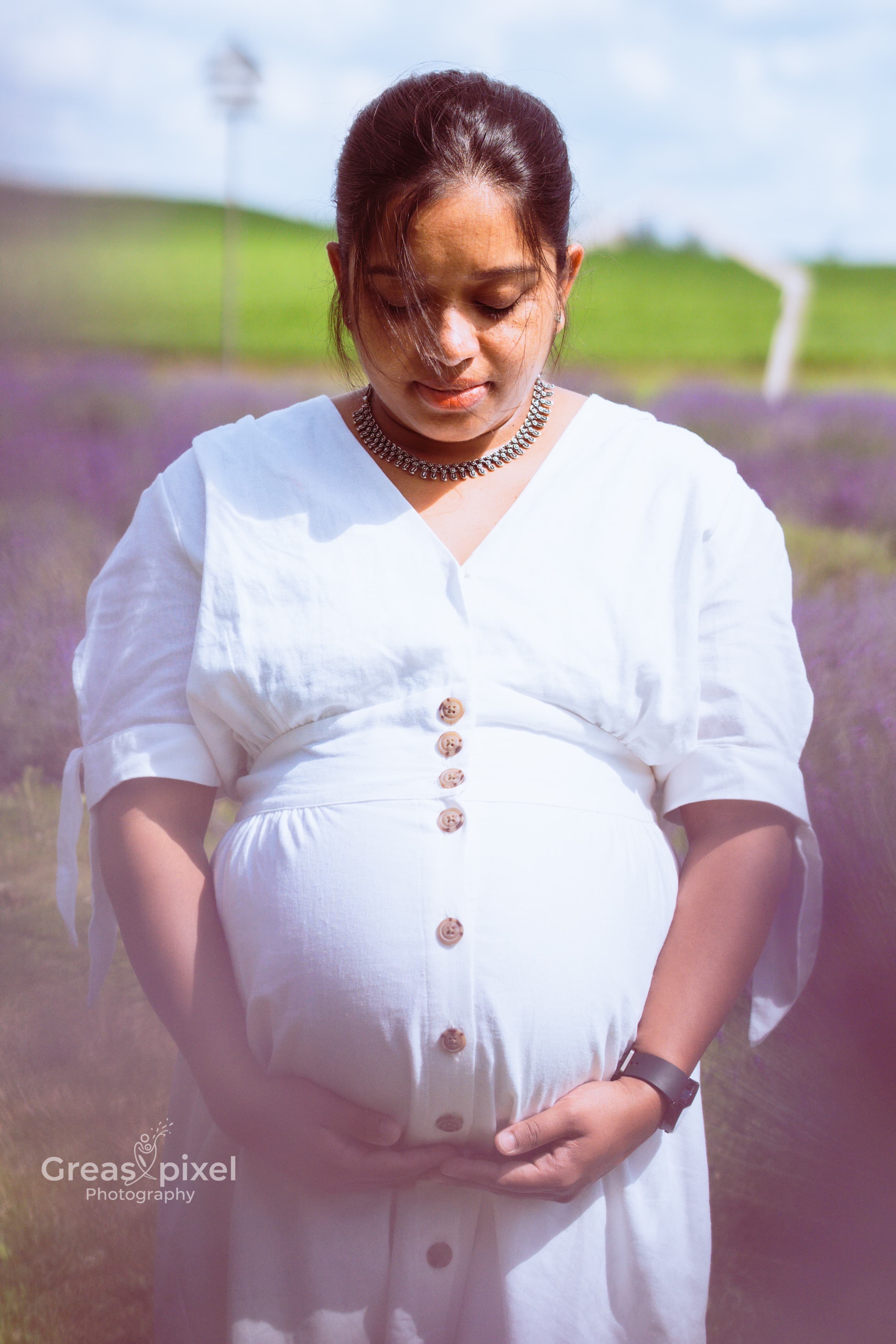 Outdoor maternity photo wearing white dress in lavender garden in Kitchener