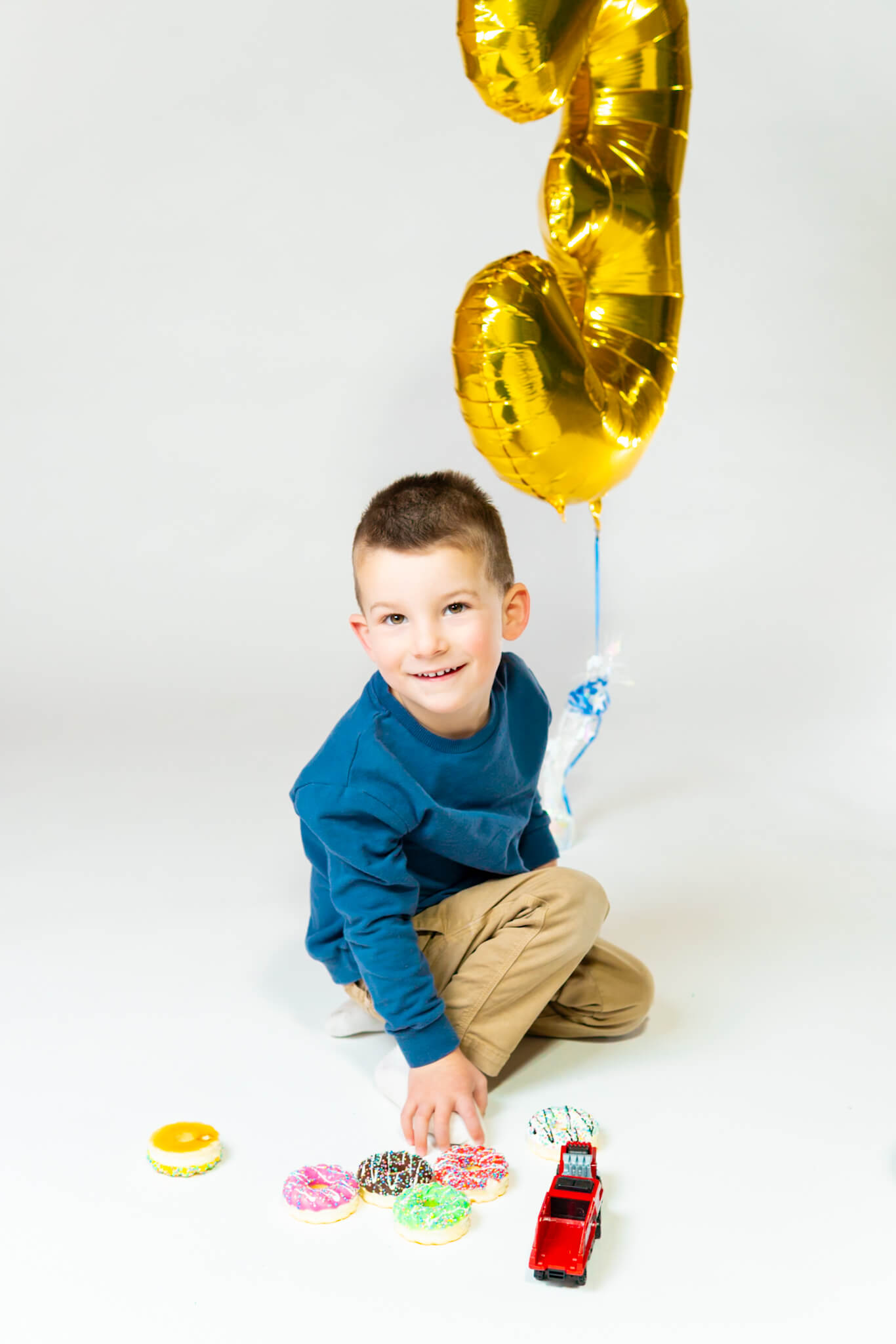 Toddler playing with balloon during birthday session by Greasypixel Photography in Kitchener